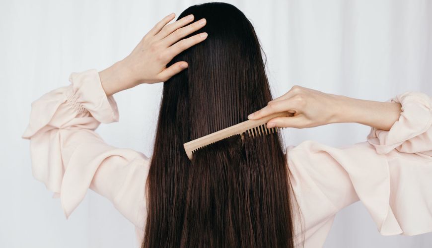 Woman brushing long brown hair