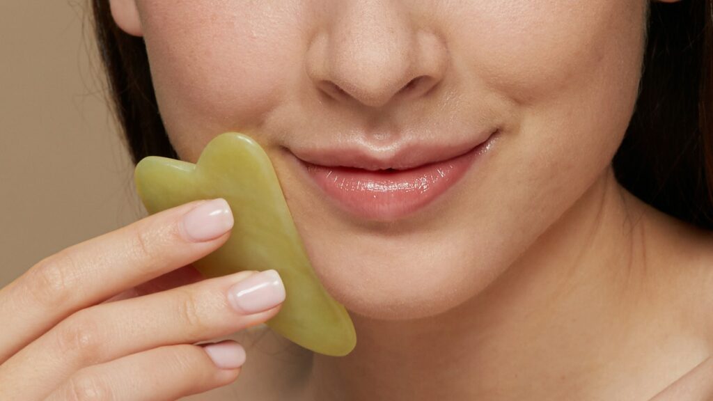 woman smiling with gua sha stone